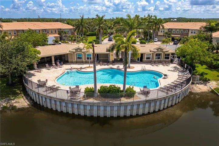Community pool with a patio area, a water view, and a residential view