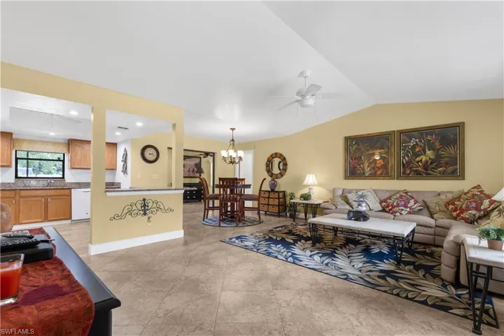 Living room featuring lofted ceiling, a ceiling fan, and a chandelier
