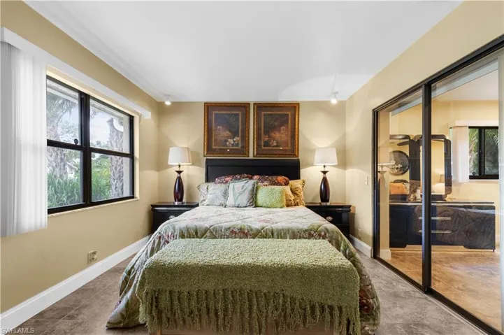 Bedroom featuring multiple windows and dark tile patterned flooring