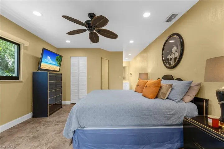 Bedroom with recessed lighting, a ceiling fan, and ensuite bathroom