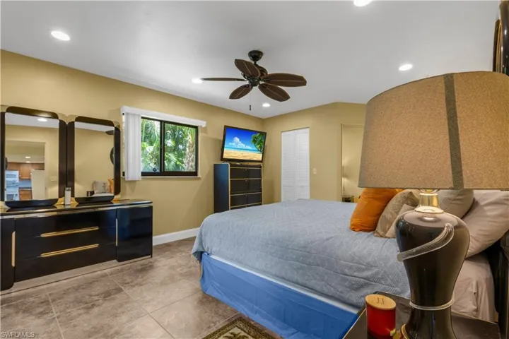 Tiled bedroom with recessed lighting and ceiling fan