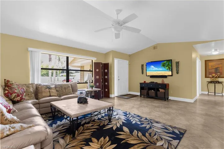 Living room with ceiling fan and vaulted ceiling