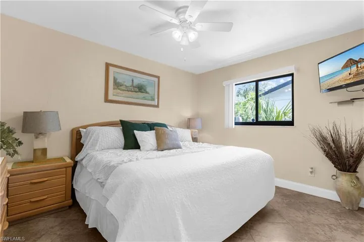 Bedroom with ceiling fan and tile patterned floors