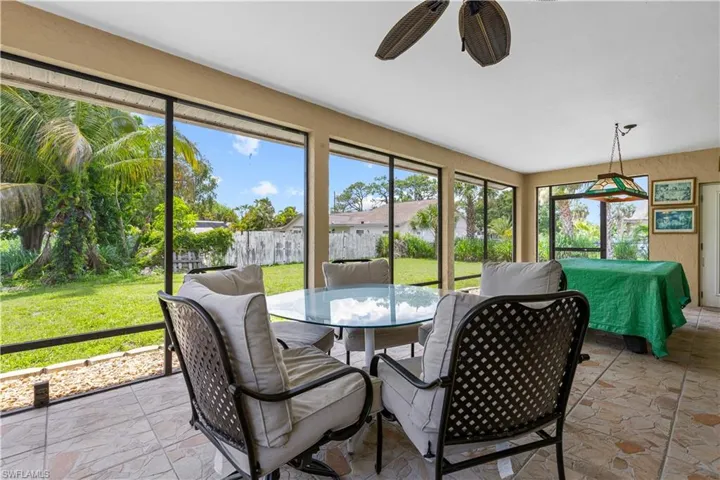 Sunroom / solarium with a ceiling fan and outdoor dining area