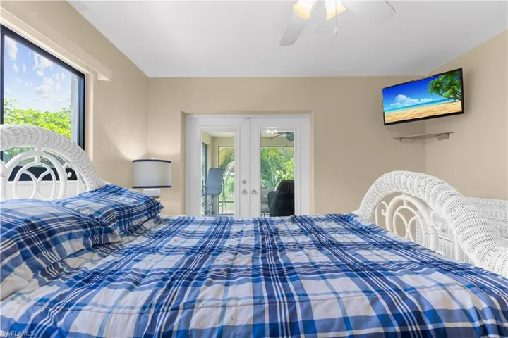 Bedroom with french doors, access to outside, and a ceiling fan