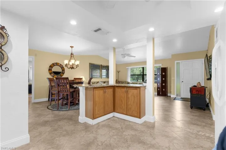 Kitchen with a ceiling fan, light stone countertops, recessed lighting, decorative light fixtures, and a chandelier