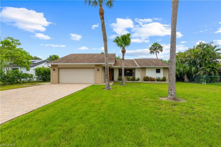Single story home featuring a garage, a front yard, and decorative driveway