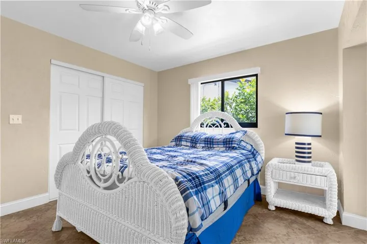 Tiled bedroom with a closet and ceiling fan