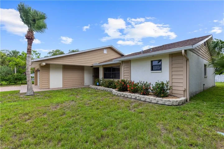 Single story home featuring an attached garage, stucco siding, and a front yard