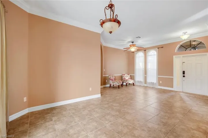 Living room with sliding doors to the lanai/pool, formal dining room and entry.