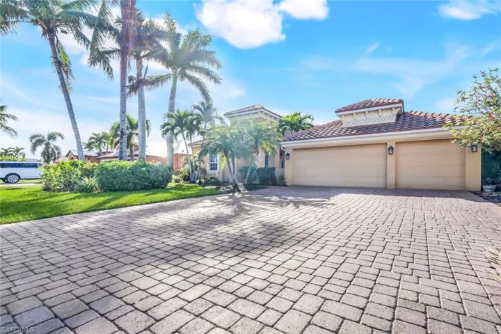 Three car garage, large paver driveway and mature landscaping.