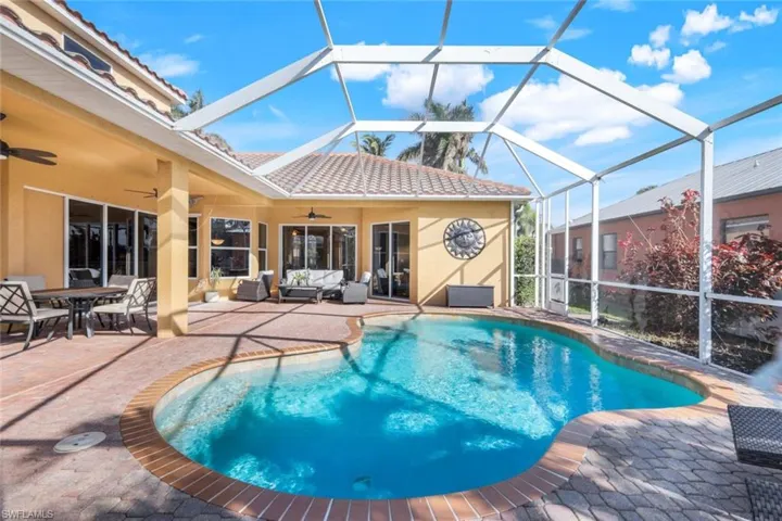 View of pool featuring outdoor lanai area, ceiling fans, paver decking and screened enclosure