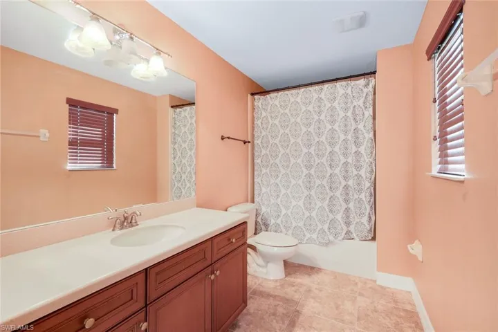 Full bathroom in upstairs bonus room with large vanity and tub/shower combination.