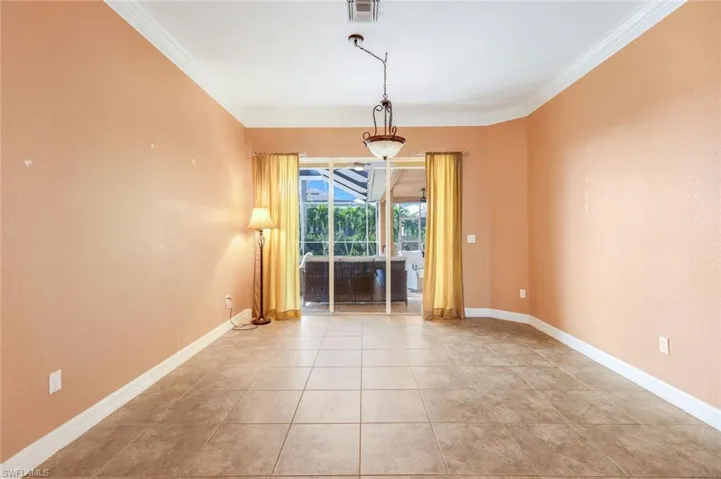 Living room has access to the lanai/pool area with crown molding.