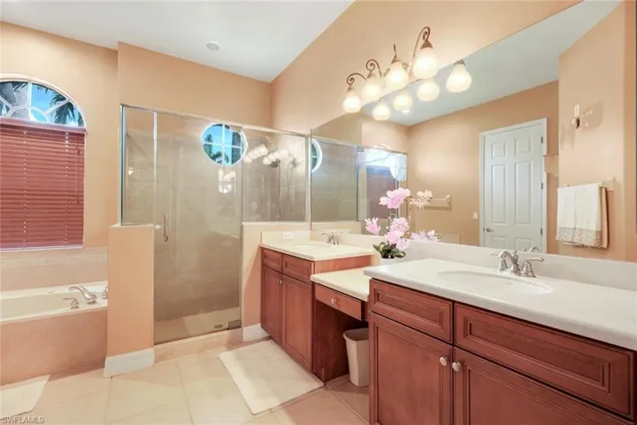 Primary bathroom featuring soaking tub, dual vanity, plus walk in shower.
