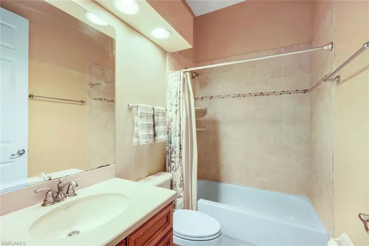 Guest bathroom #1 with tiled shower/tub combination and spacious vanity.
