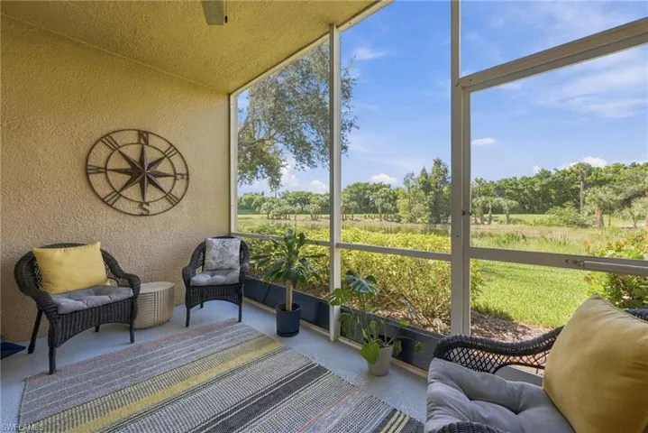 Screened-in lanai featuring a textured stucco finish and full-height window panels