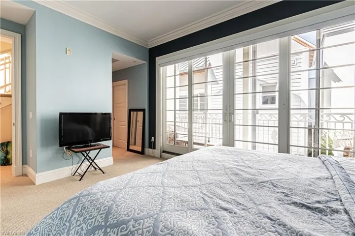 Carpeted bedroom featuring access to exterior, multiple windows, crown molding, and baseboards