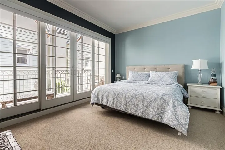 Bedroom featuring ornamental molding, access to exterior, and carpet flooring