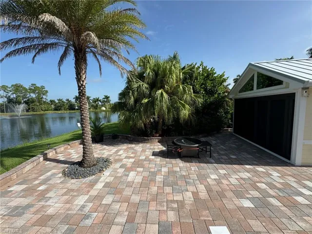 View of patio with an outdoor fire pit and a water view