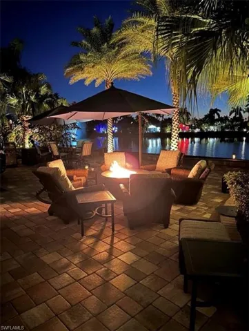 Patio at twilight featuring a water view