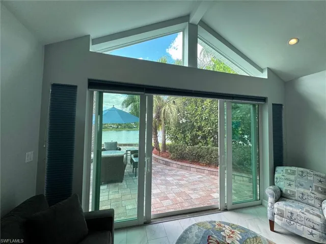 Doorway to outside featuring tile patterned flooring, a water view, and lofted ceiling with beams