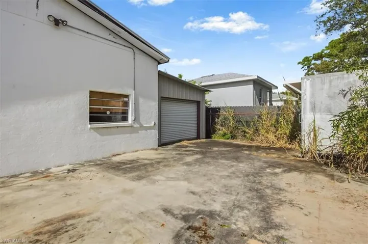 View of property exterior with concrete driveway, a garage, and stucco siding