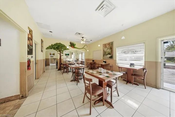 Dining area with light tile patterned flooring, a ceiling fan, plenty of natural light, and arched walkways