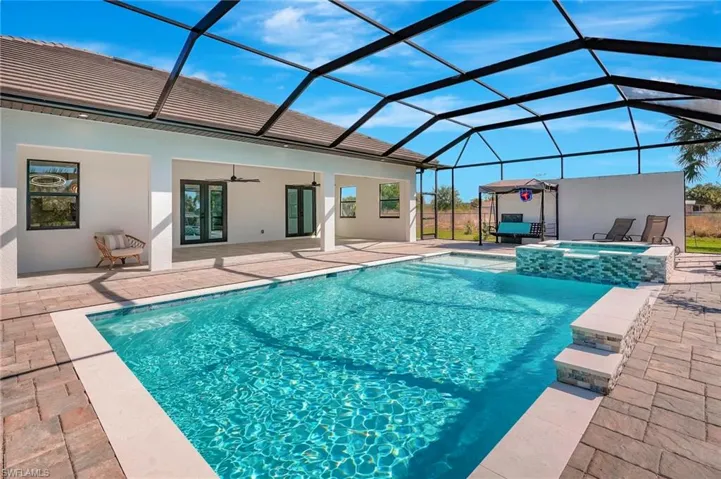 View of swimming pool with a patio, a lanai, a pool with connected hot tub, and ceiling fan