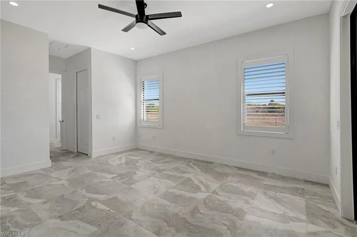 Unfurnished room with recessed lighting, ceiling fan, and baseboards