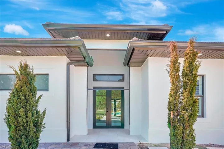Doorway to property featuring stucco siding and french doors