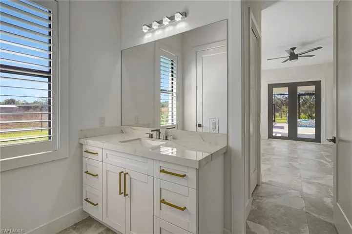 Bathroom with a healthy amount of sunlight, vanity, and a ceiling fan