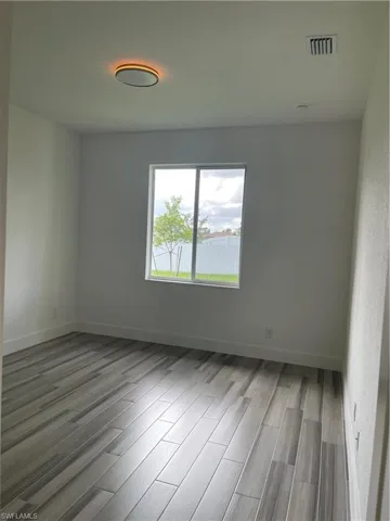 Empty room with wood tiled floors and a water view