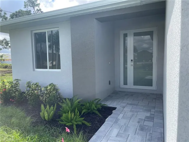Property entrance featuring stucco siding