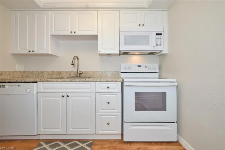 Kitchen featuring white cabinetry.