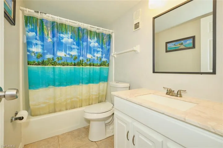 Full bathroom featuring tiled shower.