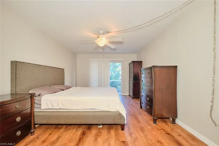Bedroom with beautiful flooring, large walk-in closet, and sliding glass doors to the screened lanai.