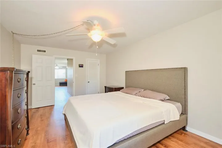 Spacious Bedroom with beautiful flooring, large walk-in closet, and sliding glass doors to the screened lanai.
