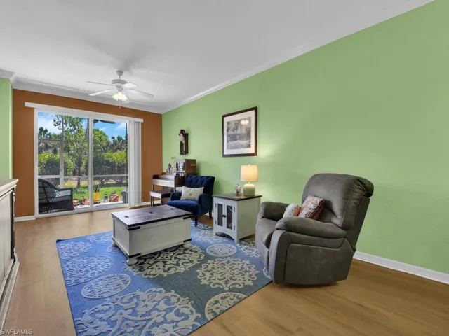 Living area with crown molding, baseboards, a ceiling fan, and wood finished floors