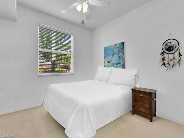 Carpeted bedroom featuring a ceiling fan and baseboards