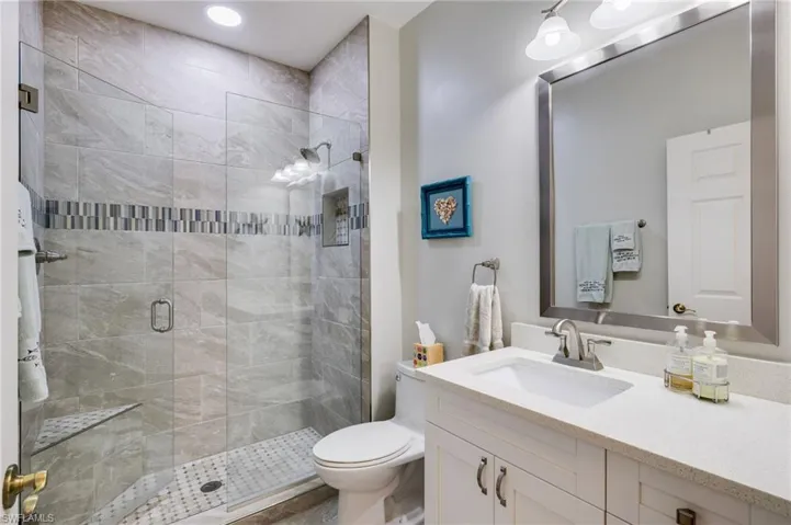 Bathroom with vanity, a stall shower, and recessed lighting