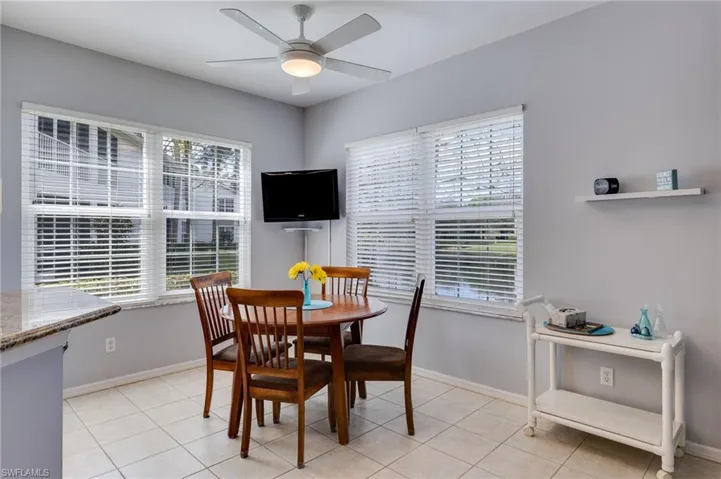 Dining space featuring light tile patterned floors, plenty of natural light, and ceiling fan