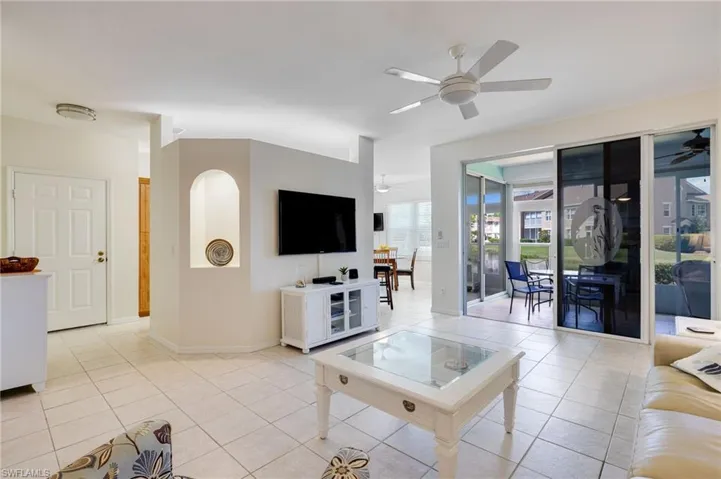 Living room with light tile patterned floors and ceiling fan