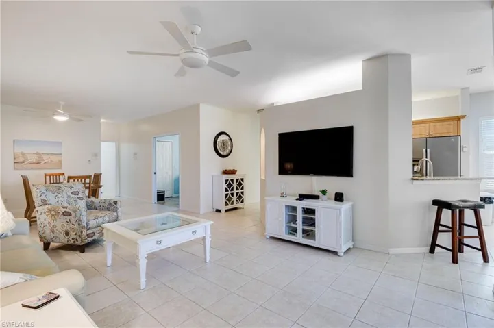Living area with a ceiling fan and light tile patterned floors