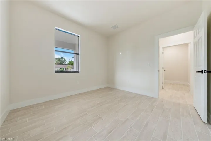 Unfurnished room featuring baseboards and wood finish floors