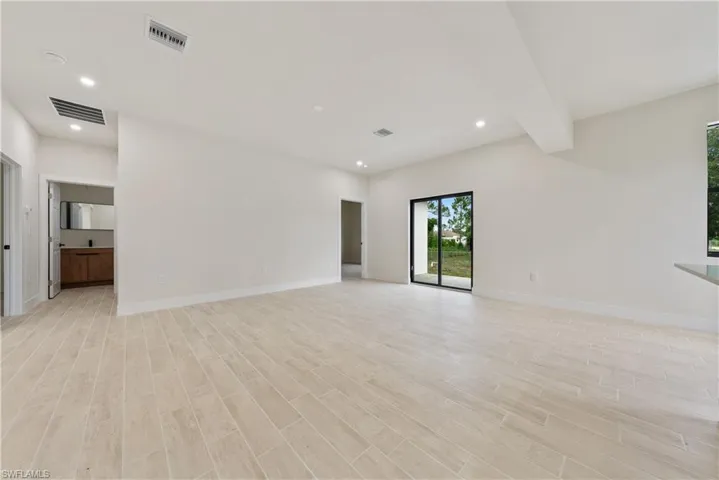Empty room with recessed lighting, light wood-style floors, and beam ceiling