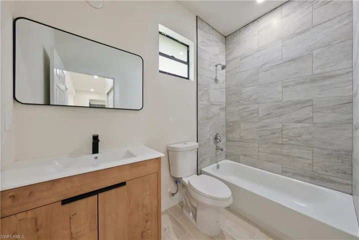 Full bath featuring bathtub / shower combination, vanity, and recessed lighting