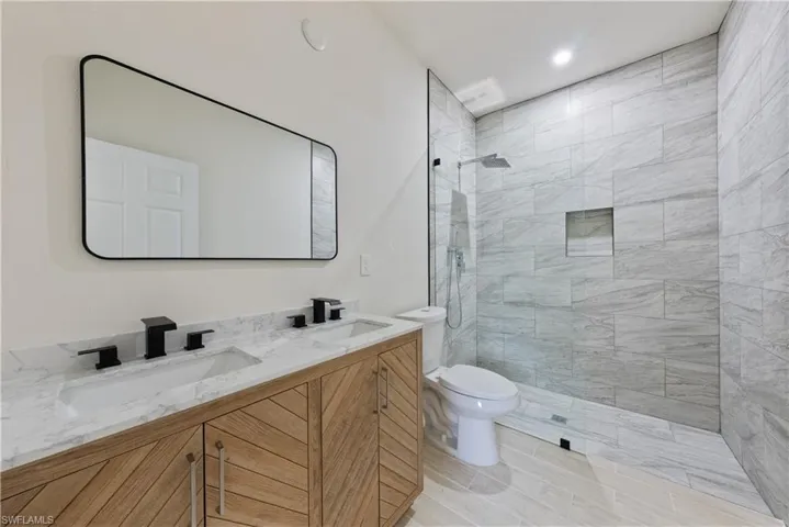 Full bathroom with walk in shower, double vanity, and recessed lighting