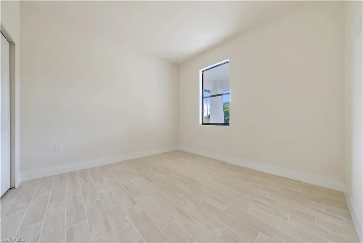 Spare room featuring baseboards and wood tiled floors
