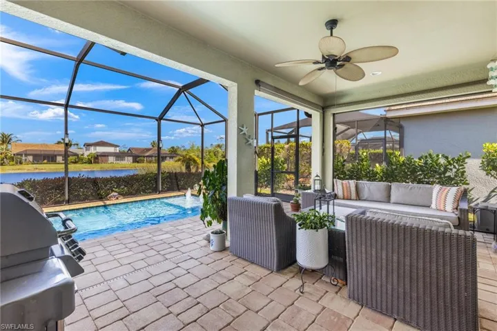 View of patio / terrace with glass enclosure, pool water feature, an outdoor hangout area, area for grilling, and ceiling fan